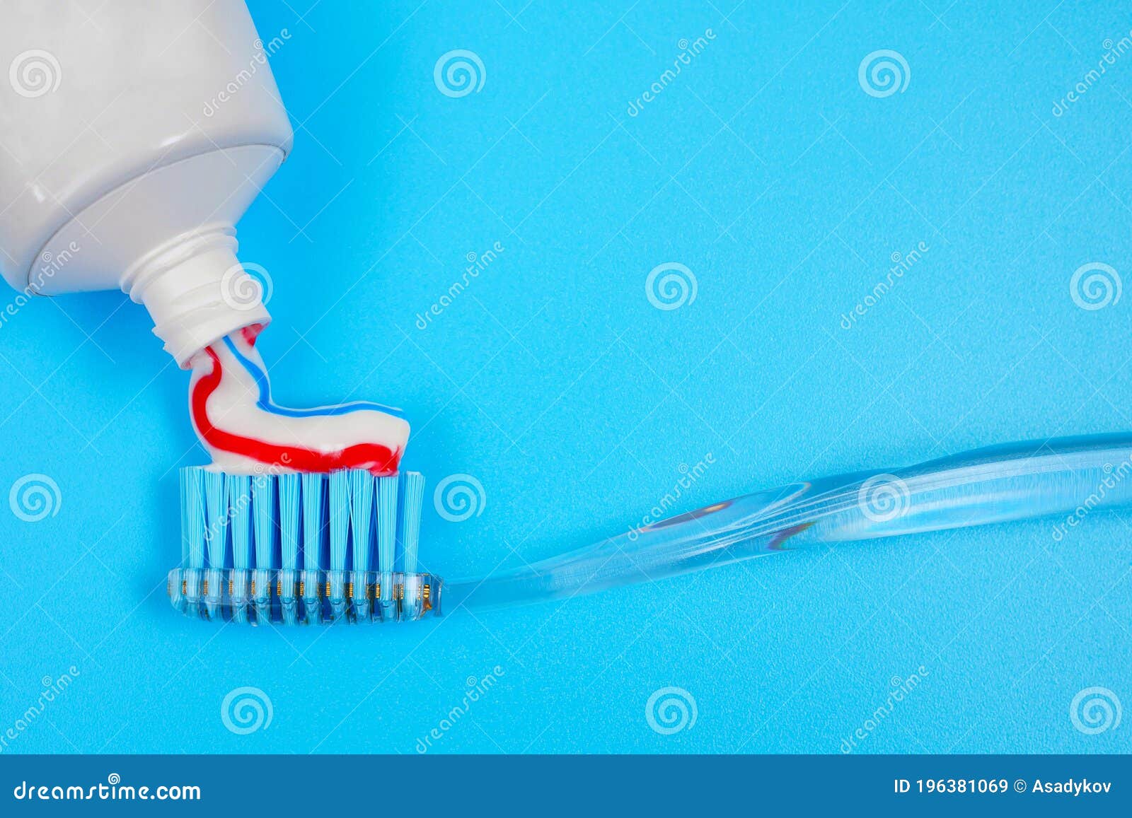 Toothbrush With Toothpaste On Blurred Glass Of Water Background Royalty