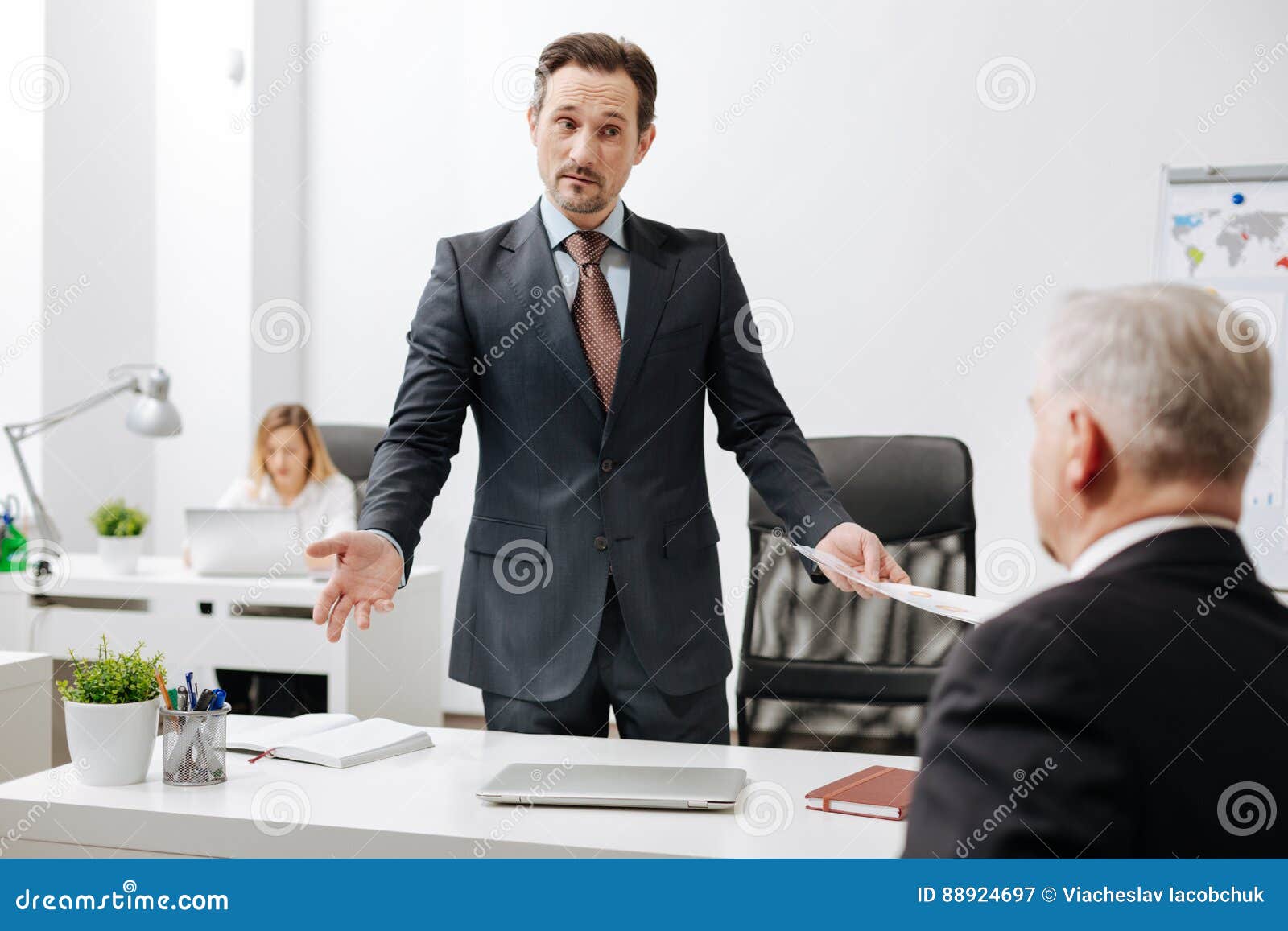 puzzled employer having conversation with colleague in the office