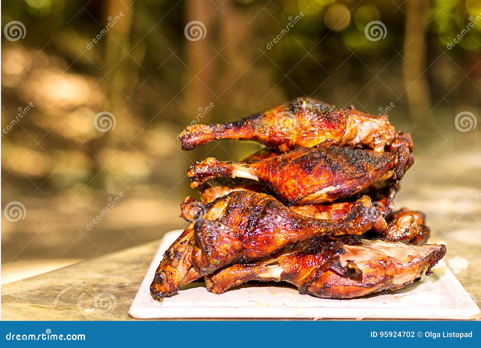 Pyramid of Grilled Duck Legs on the Board. Outdoor Barbeque Stock Photo
