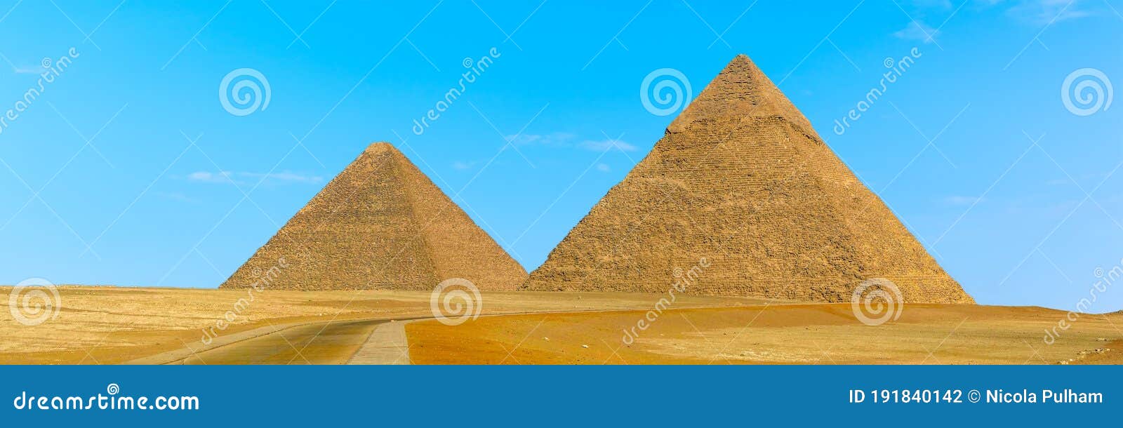 pyramids at giza, egypt protrude majestically into a blue cloudless sky