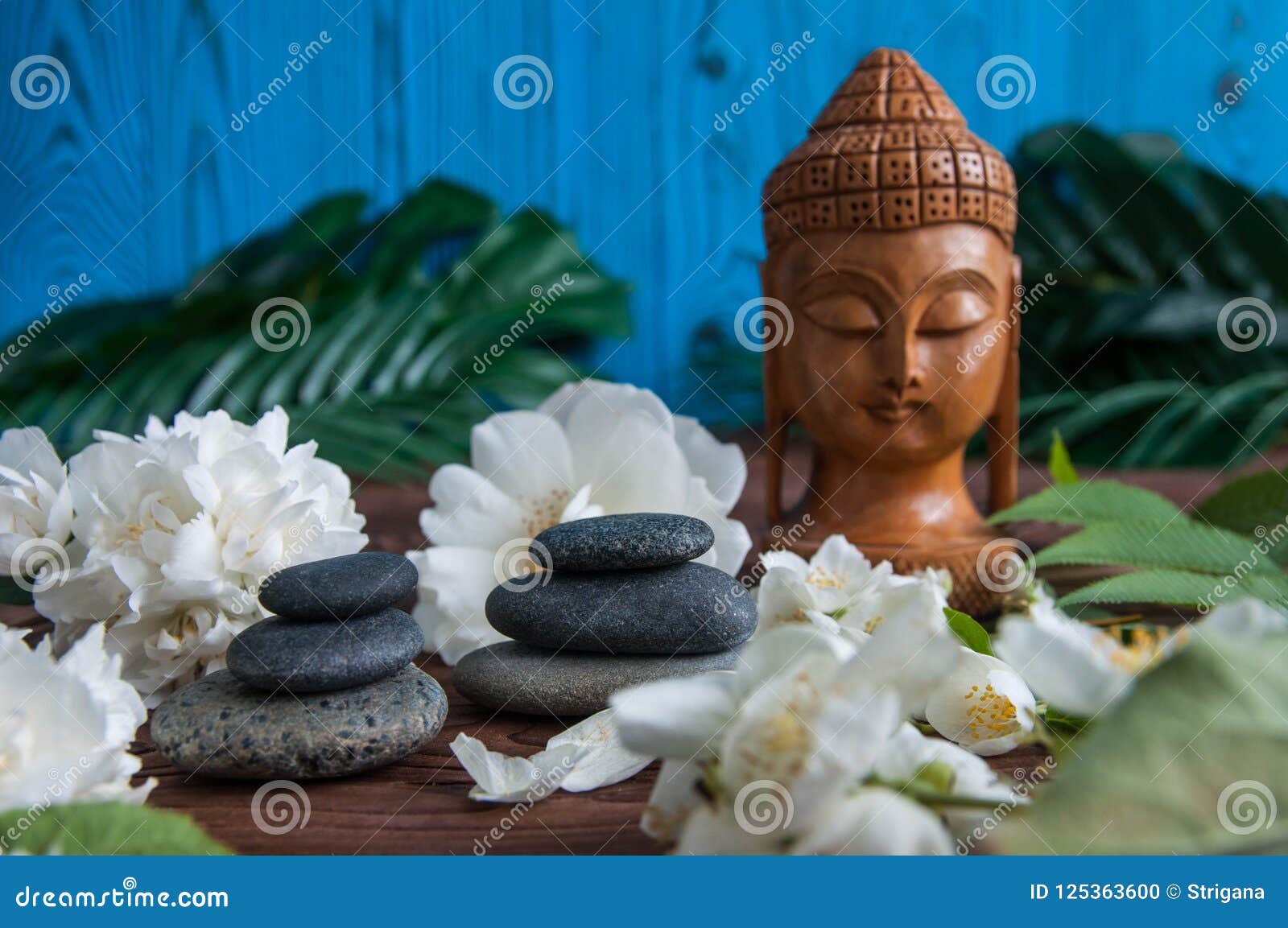 Pyramids of Gray Zen Stones with White Flowers, Green Leaves on Wooden ...