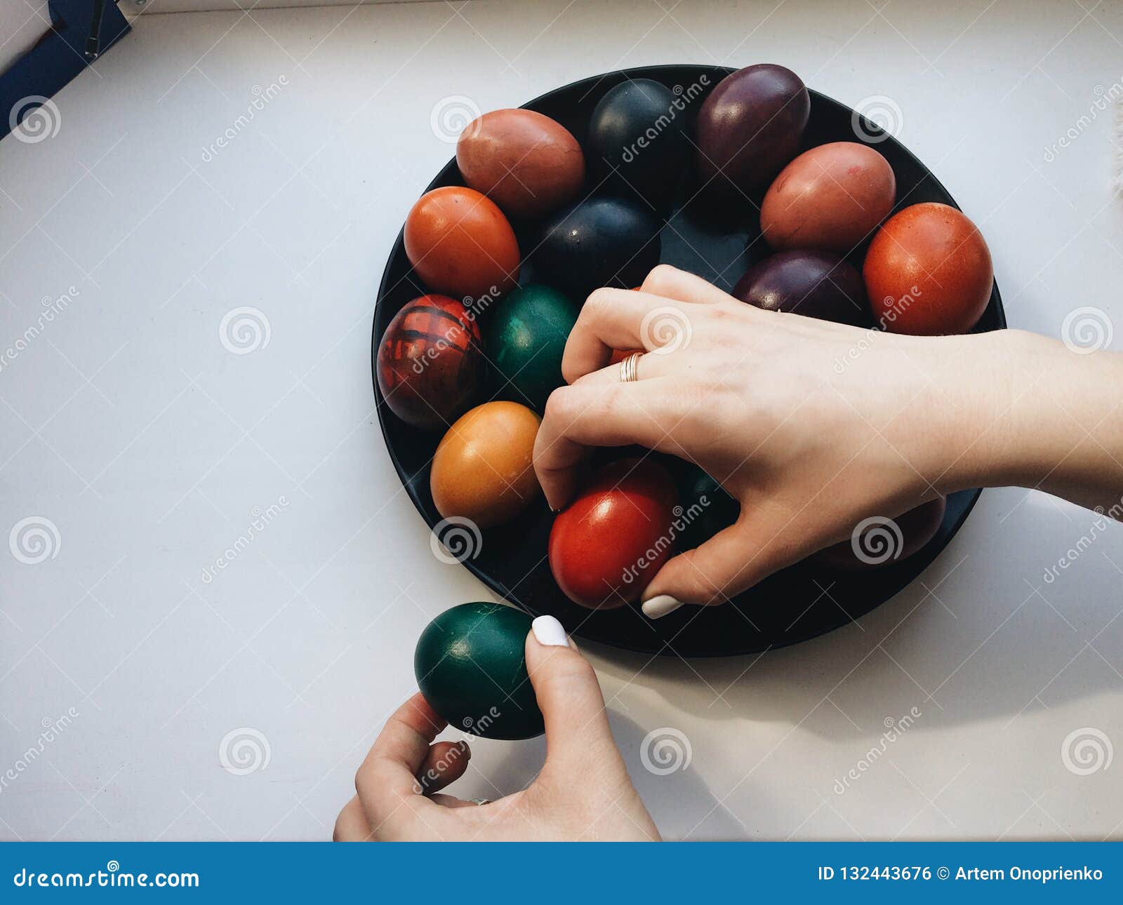 Pâques, vacances, tradition et concept de personnes Fermez-vous des mains de la femme caucasienne tenant des oeufs de pâques avec des couleurs