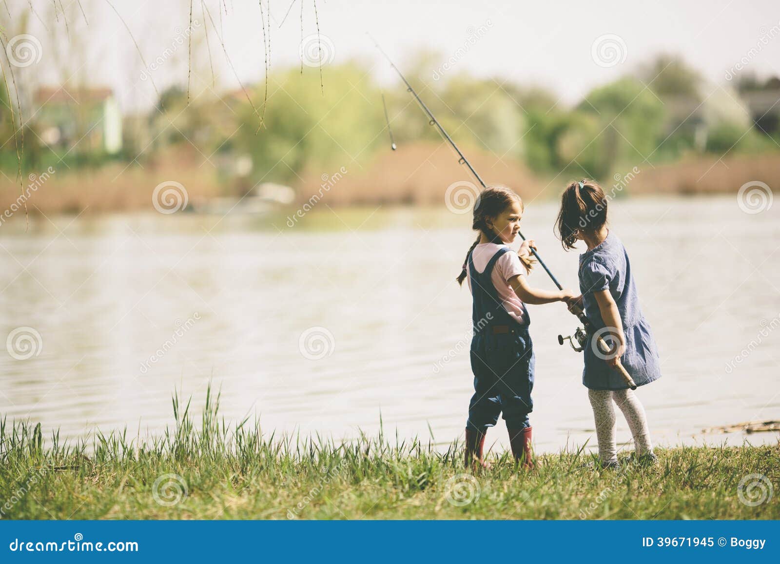 Pêche de deux petites filles. Deux petites filles pêchant sur un lac