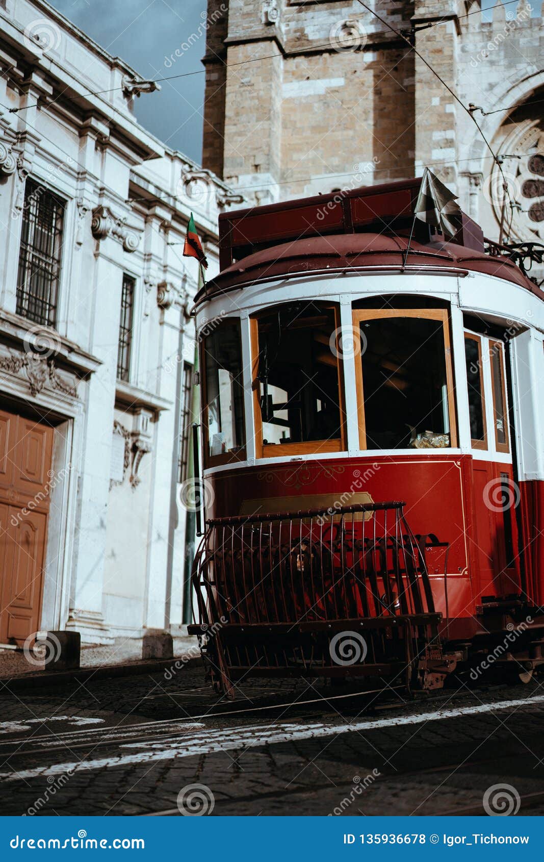 quaint tram passes directly in front of the se cathedral in lisbon. lisboa lissabon