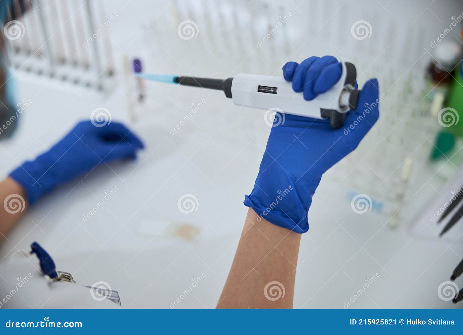 qualified biochemist using a laboratory tool for a blood test