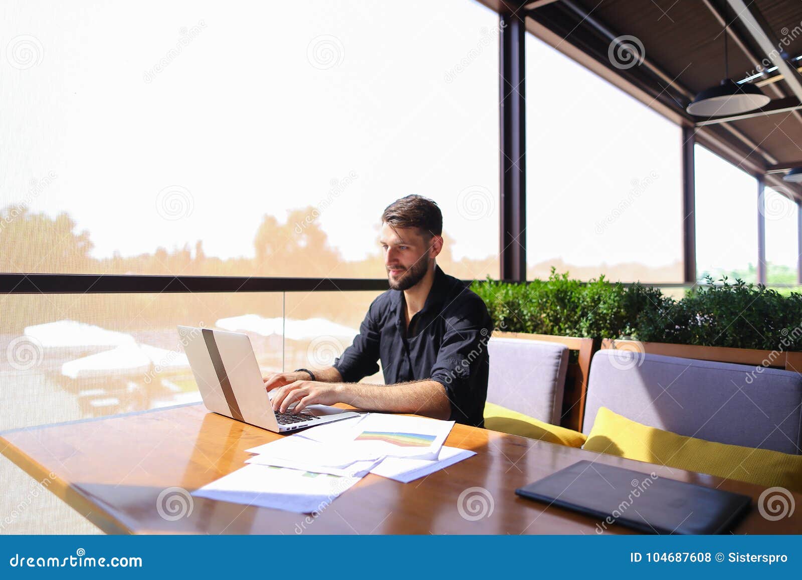 Quantity Surveyor Working At Cafe Table With Papers And Laptop