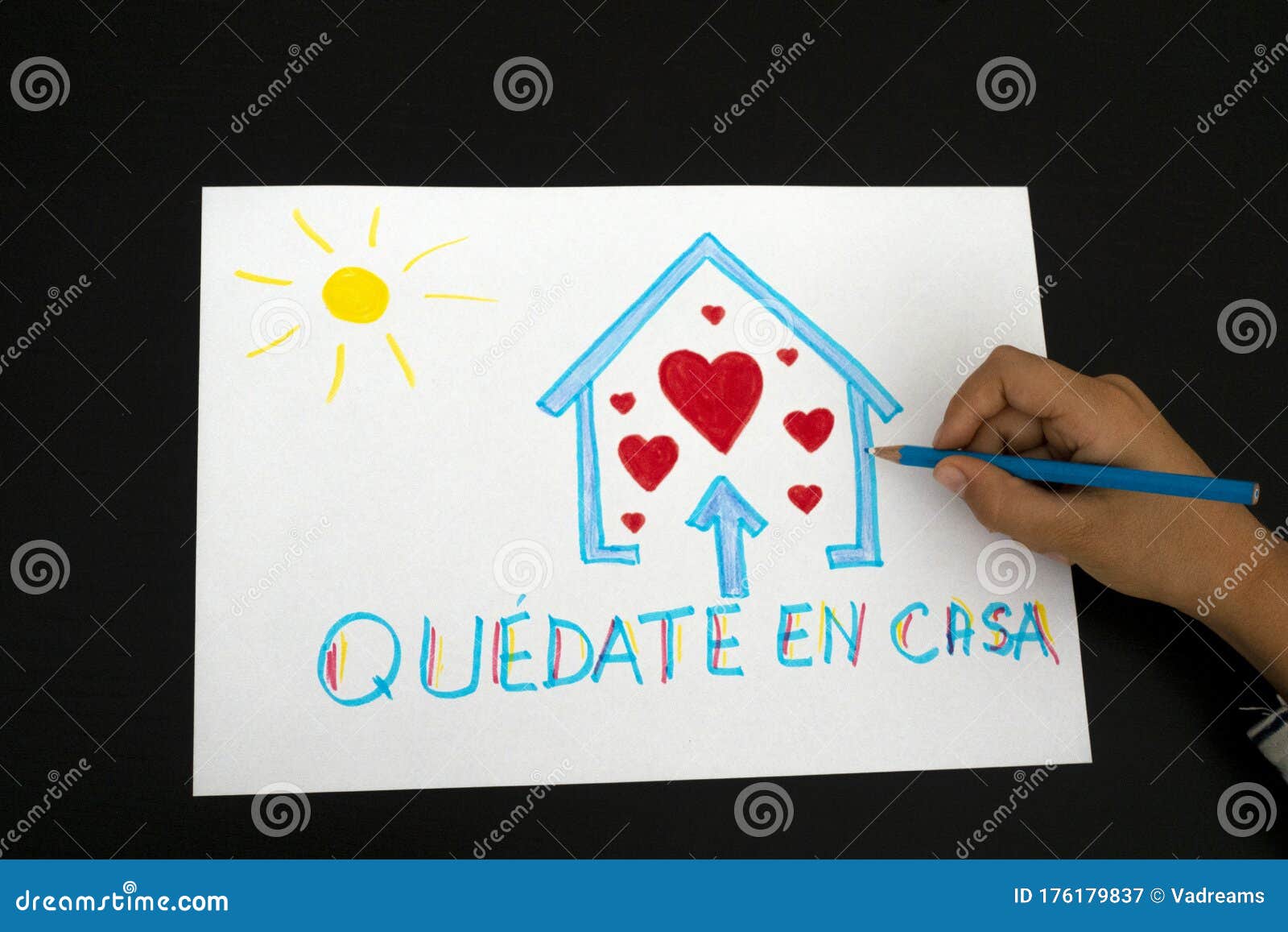 quarantine in spain. kid hand draw picture with spanish words quedate en casa - stay at home