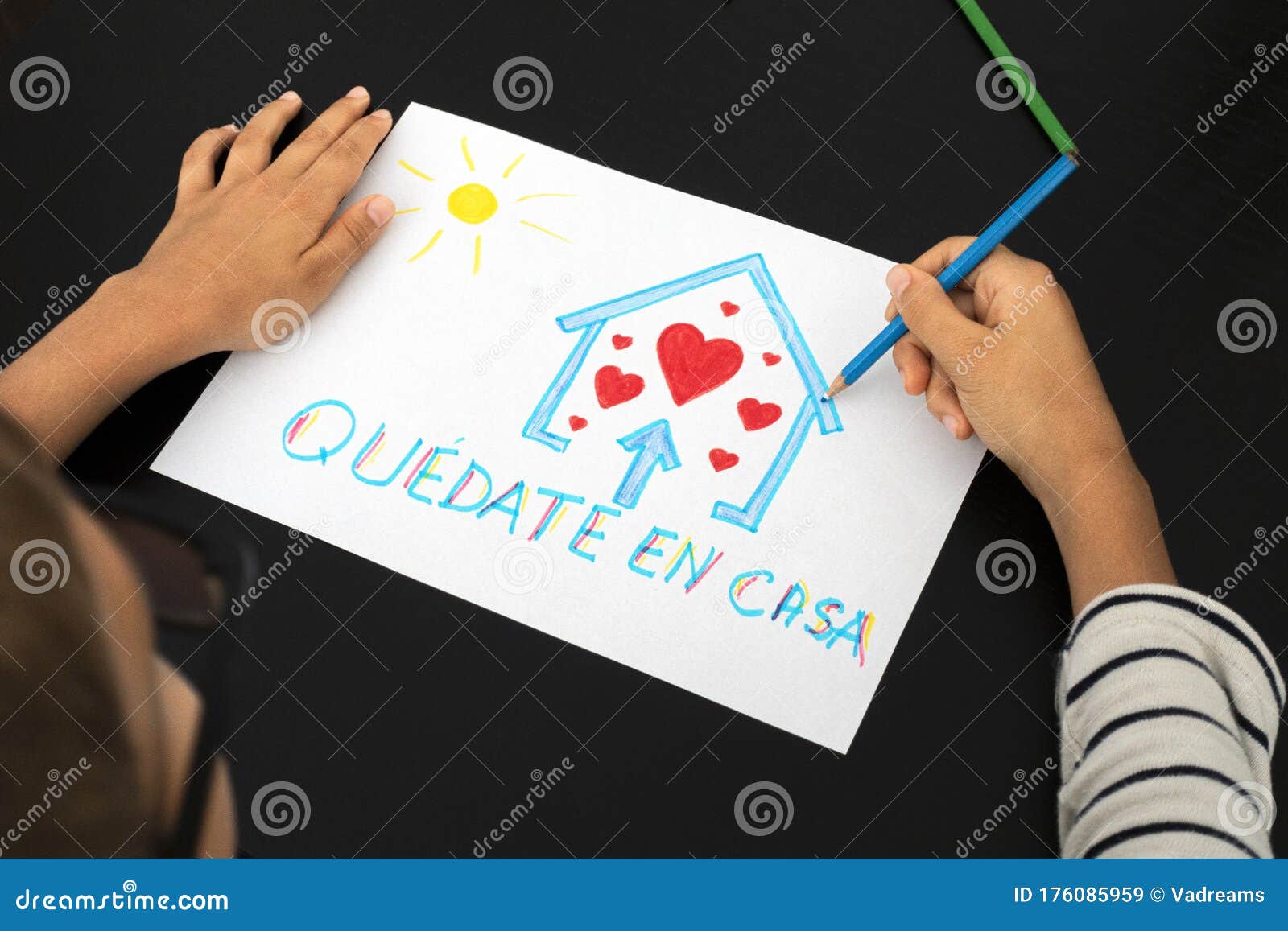 quarantine in spain. kid hand draw picture with spanish words quedate en casa - stay at home