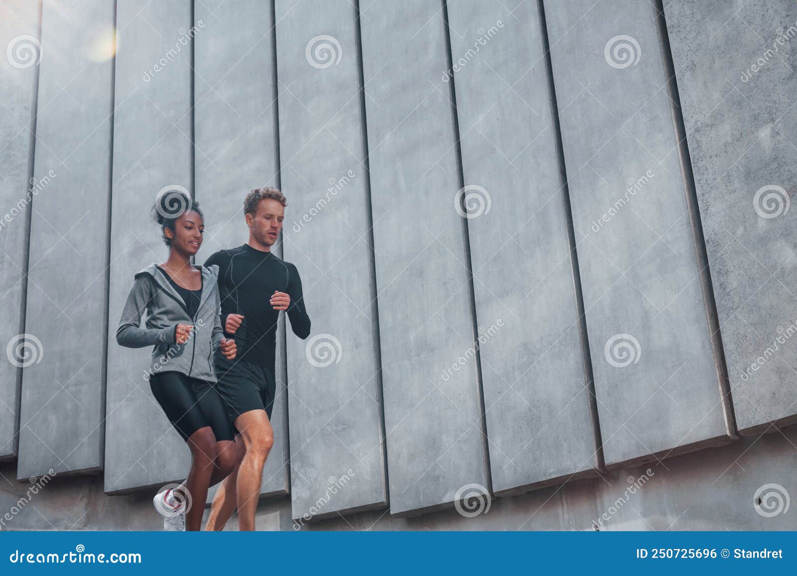 Quase Grande Parede. Homem Europeu E Mulher Africana-americana Em Trajes  Esportivos Têm Trabalhado Juntos Foto de Stock - Imagem de cidade,  americano: 250725696