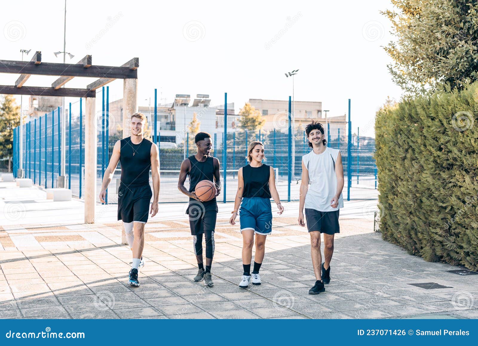 Grupo de pessoas multiétnicas jogando basquete na quadra