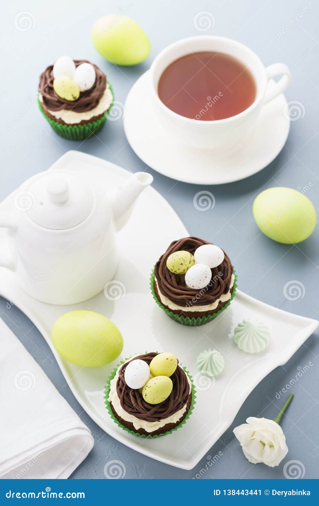 Queques do chocolate da Páscoa com os ovos do ninho e de doces para a sobremesa. Queques do chocolate da Páscoa decorados com os ovos do ninho e de doces para a sobremesa Ajuste da tabela do feriado