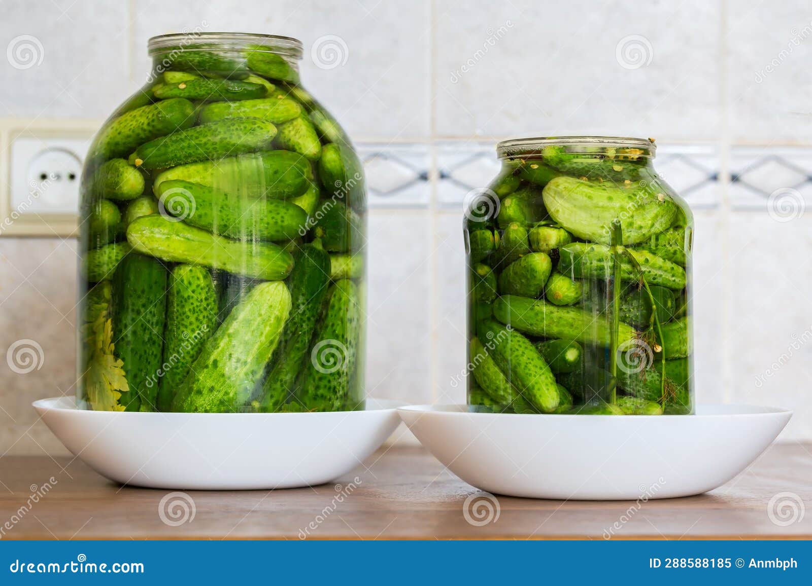 Quick Pickled Cucumbers in Two Different Jars on Kitchen Table Stock