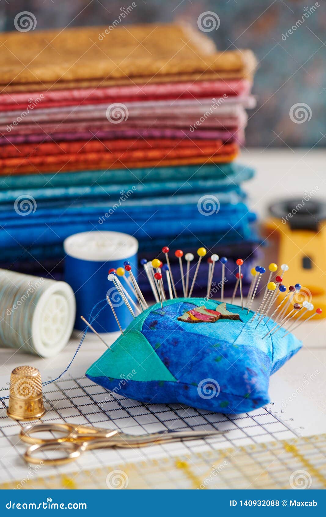 Quilting Accessories on the Background of a Stack of Bright Quilting