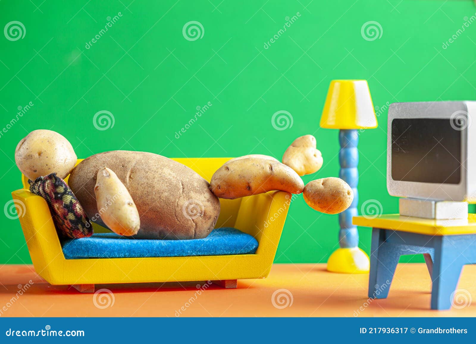 a quirky metaphorical concept image showing a potato man lying on a couch in a living room setting