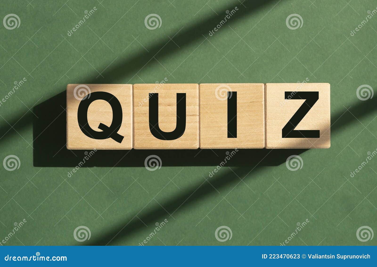 quiz word on wooden cubes on green sunny background. quizz game concept