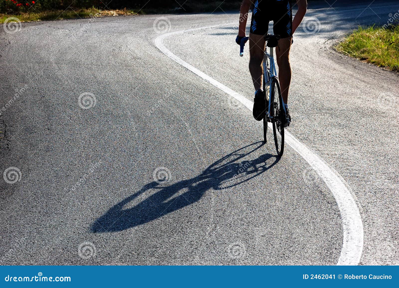 Radfahrerreiten ansteigend. Ein Radfahrerreiten auf einer ansteigenden landwirtschaftlichen Straße