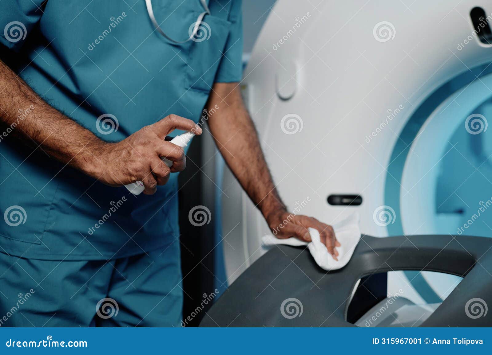 radiographer cleaning ct scanner bed