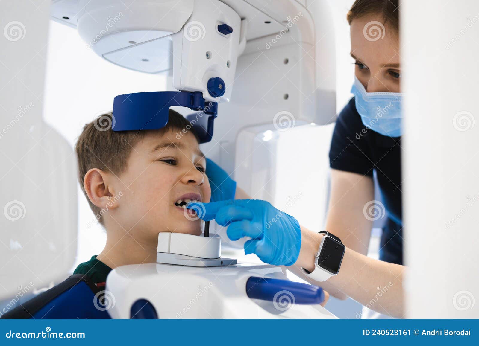 radiographer taking panoramic teeth radiography to a little boy using modern x-ray machine.