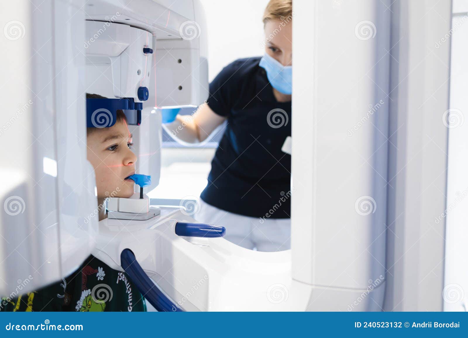 radiographer taking panoramic teeth radiography to a little boy using modern x-ray machine.