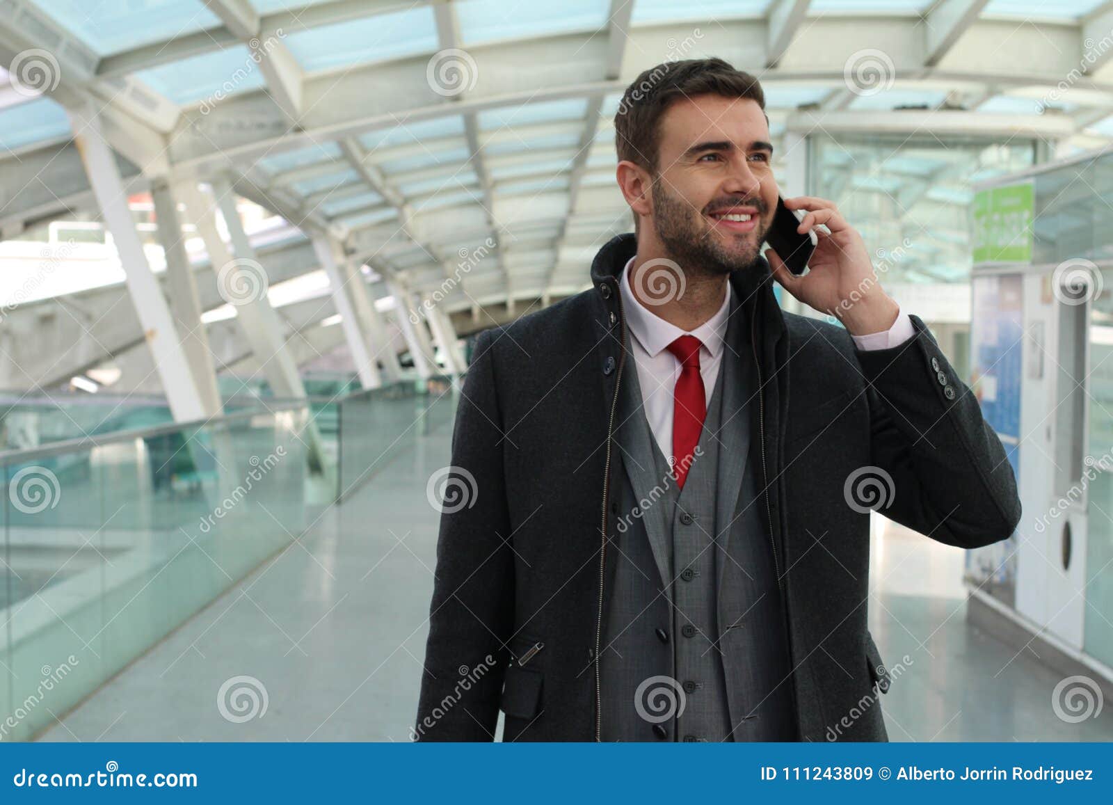 Radosny biznesmen dzwoni telefonem od dworca