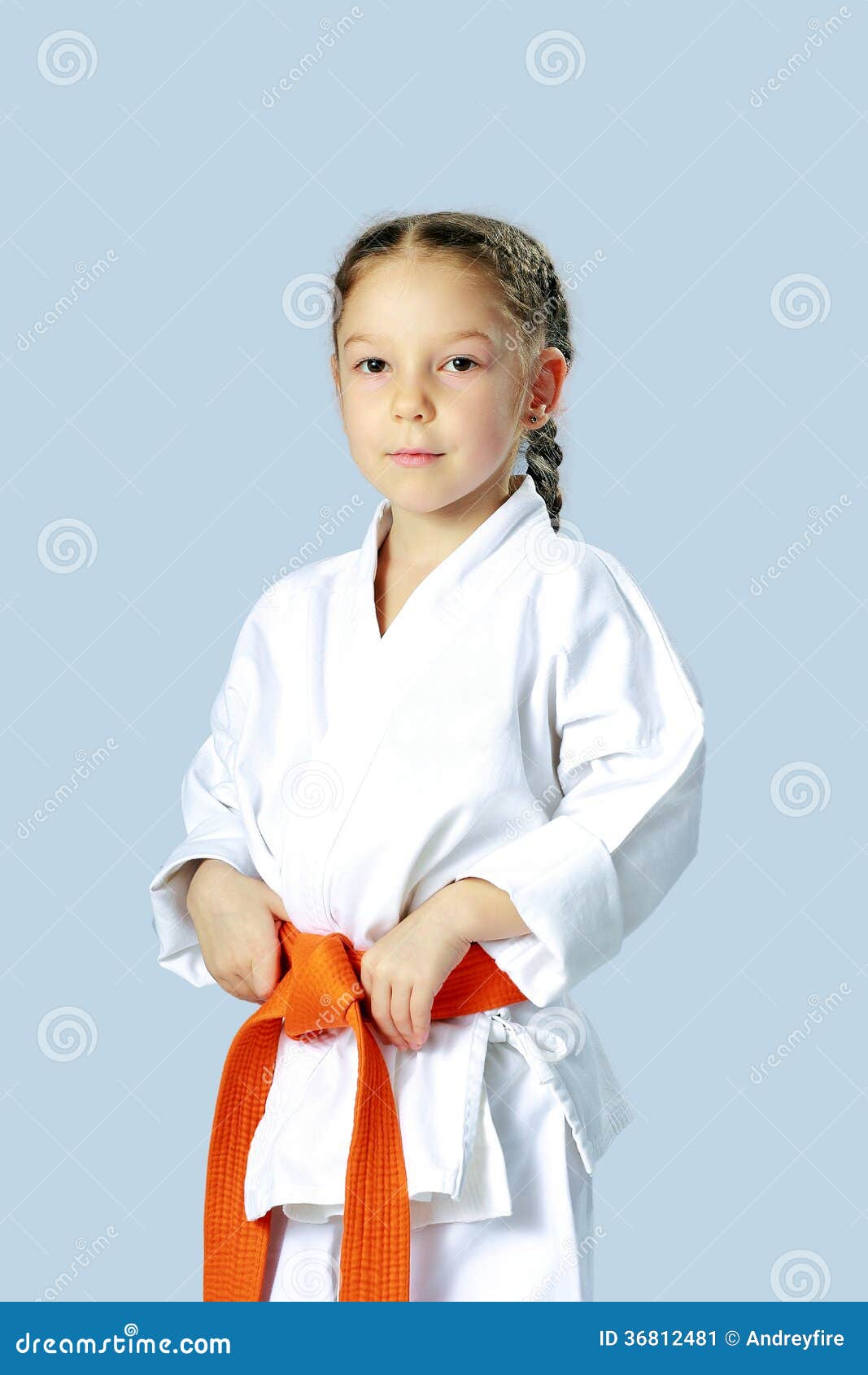 Ragazza dell'atleta in un kimono con la cinghia arancio. Ragazza in un kimono con la cinghia arancio
