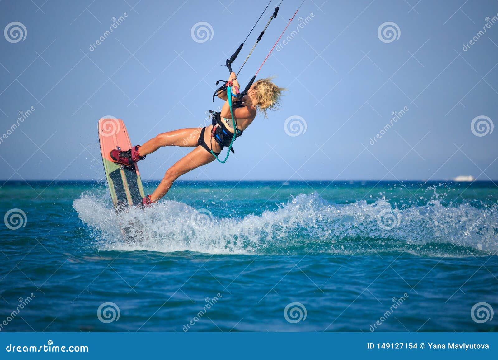 ragazza-praticante-il-surfing-dell-aquilone-costume-da-bagno-sexy-con-l-cielo-bordo-nelle-onde-di-guida-del-mare-blu-la-149127154