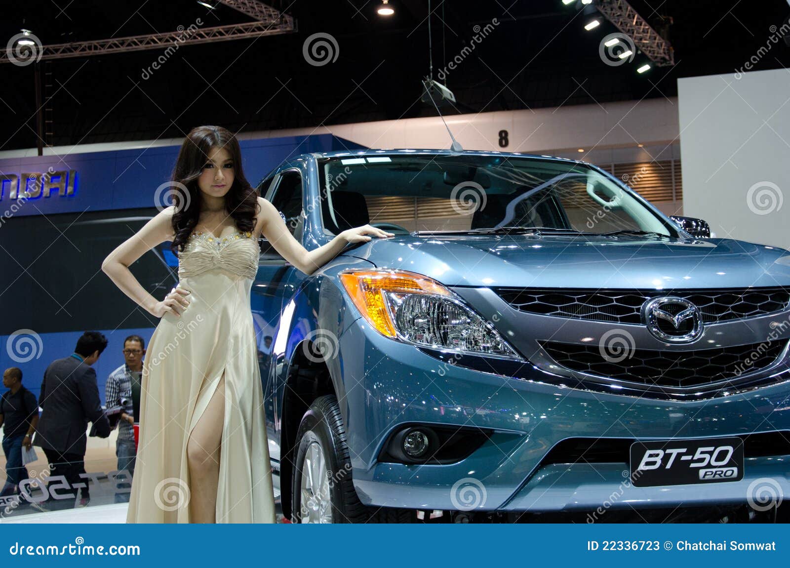 Ragazze graziose con Mazda. BANGKOK - 3 DICEMBRE: Automobile di Mazda BT-50 con il modello non identificato su visualizzazione alla ventottesima Expo internazionale del motore della Tailandia il 3 dicembre 2011 a Bangkok, Tailandia.