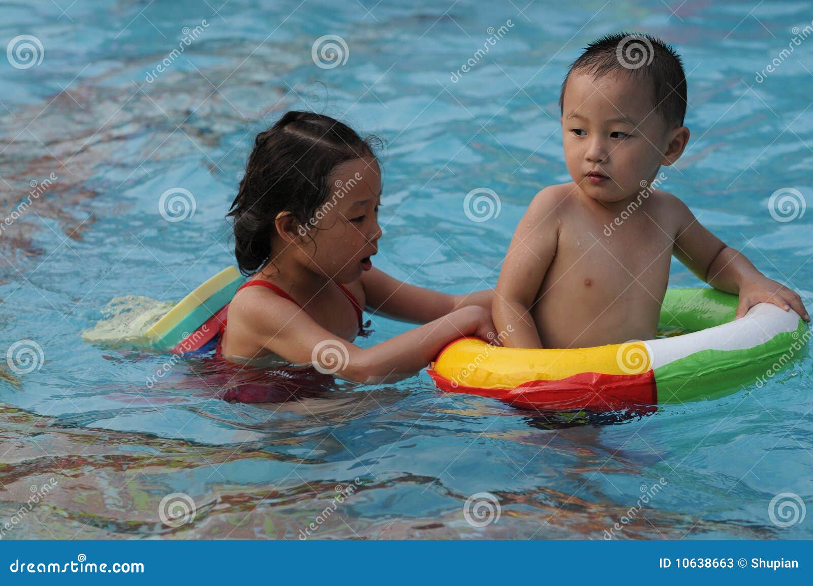 Ragazzo e ragazza di nuoto. Un bambino bello e una ragazza graziosa sono swimmingã