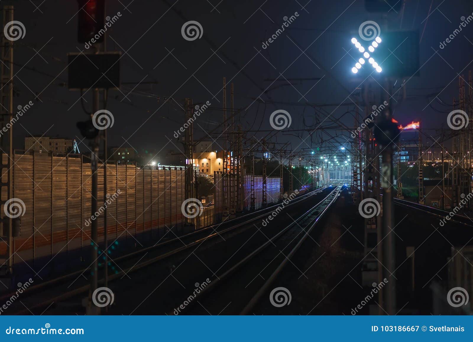 Railroad Night Scene with Blue Traffic Light and Railway Station Tracks ...
