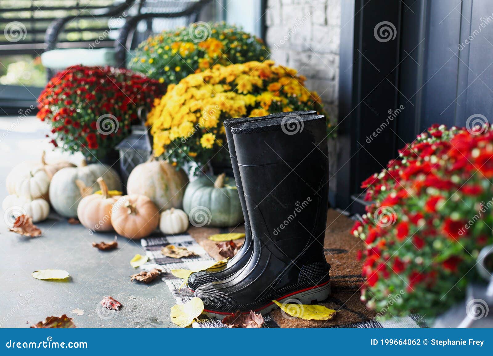 rain boots on front porch decorated for autumn
