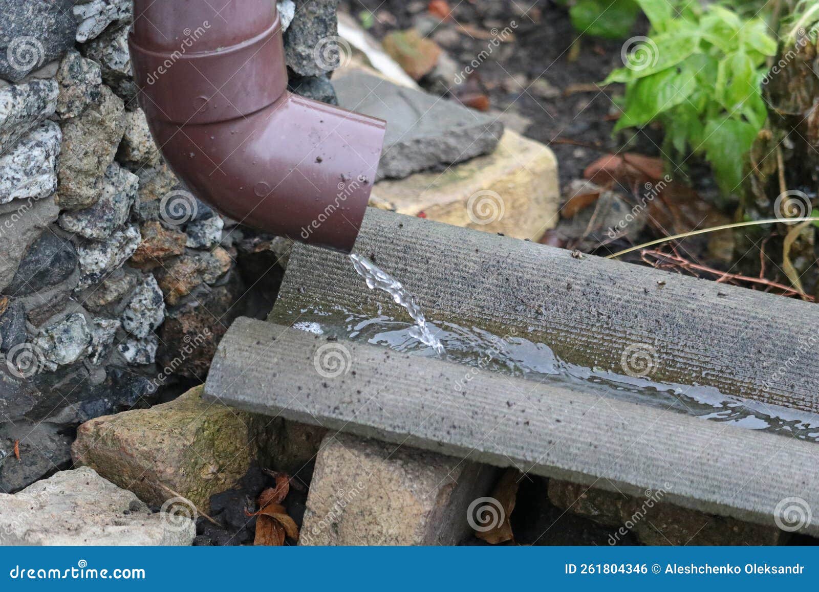 Rain Water Flows Out of the Gutter Pipe. Stock Photo Image of