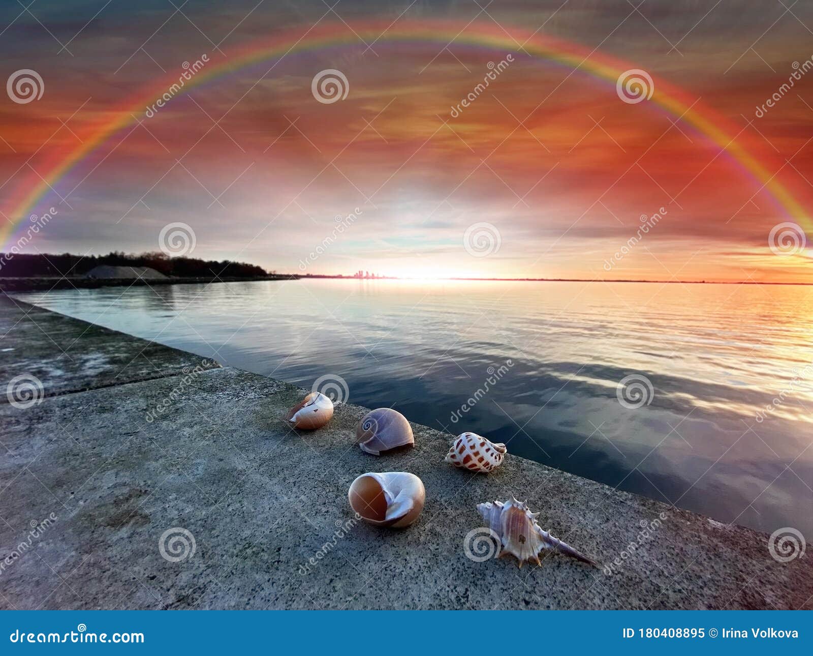 Rainbow at cloudy blue pink sky at sunset sea reflection on water and seashell on beach stones nature landscape , sky at pink sunset sea water blue reflection and seashell on beach stone nature landscape banner background