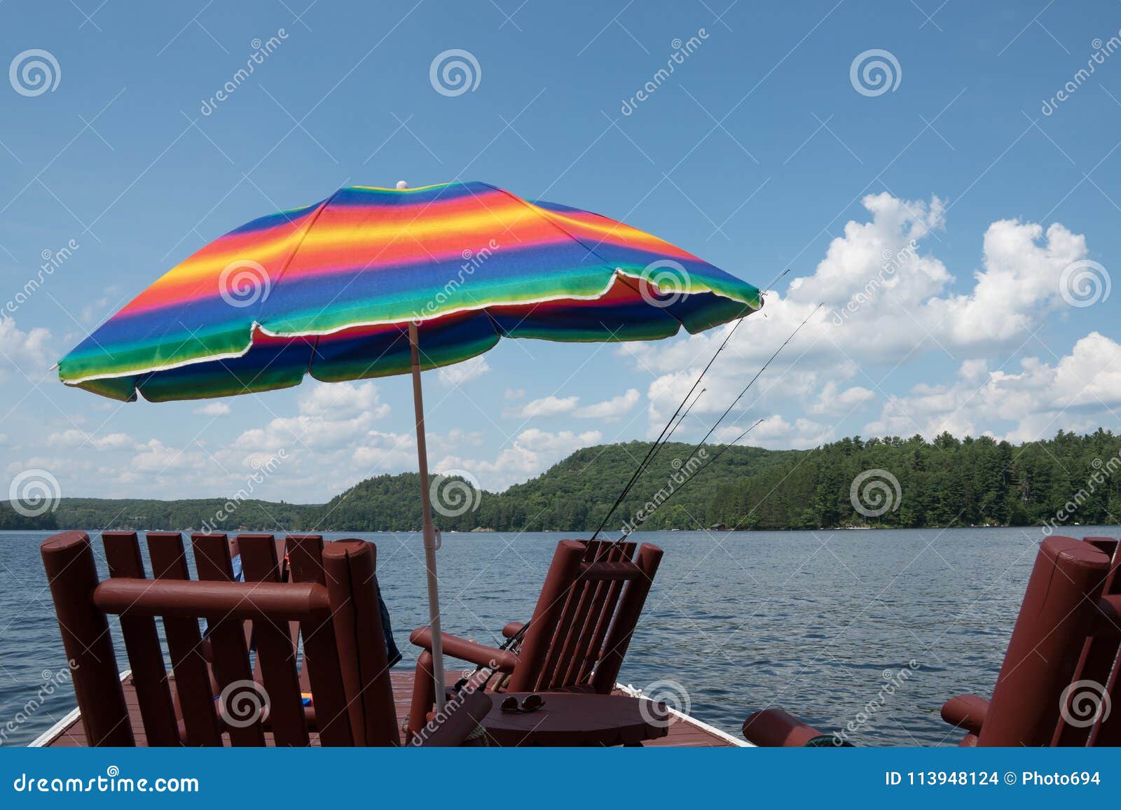 A Multi-colored Sunshade Umbrella on a Lakeside Dock Stock Photo