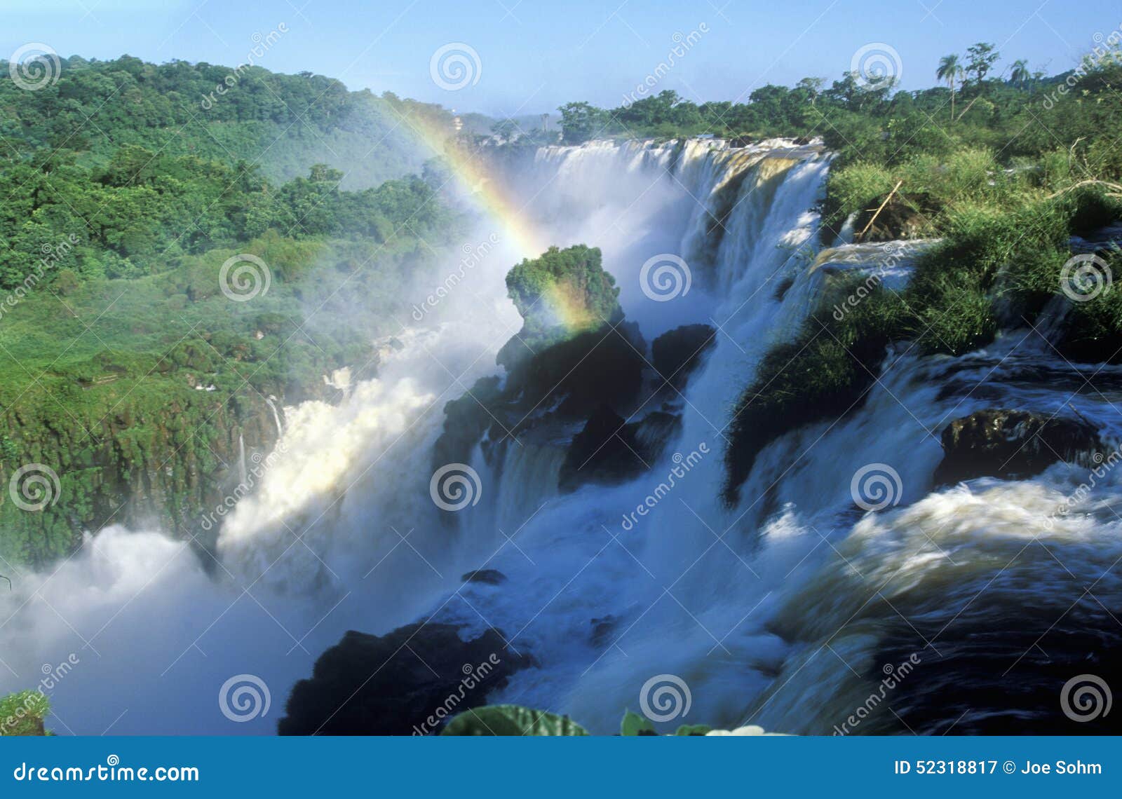 rainbow over iguazu waterfalls in parque nacional iguazu viewed from upper circuit, border of brazil and argentina