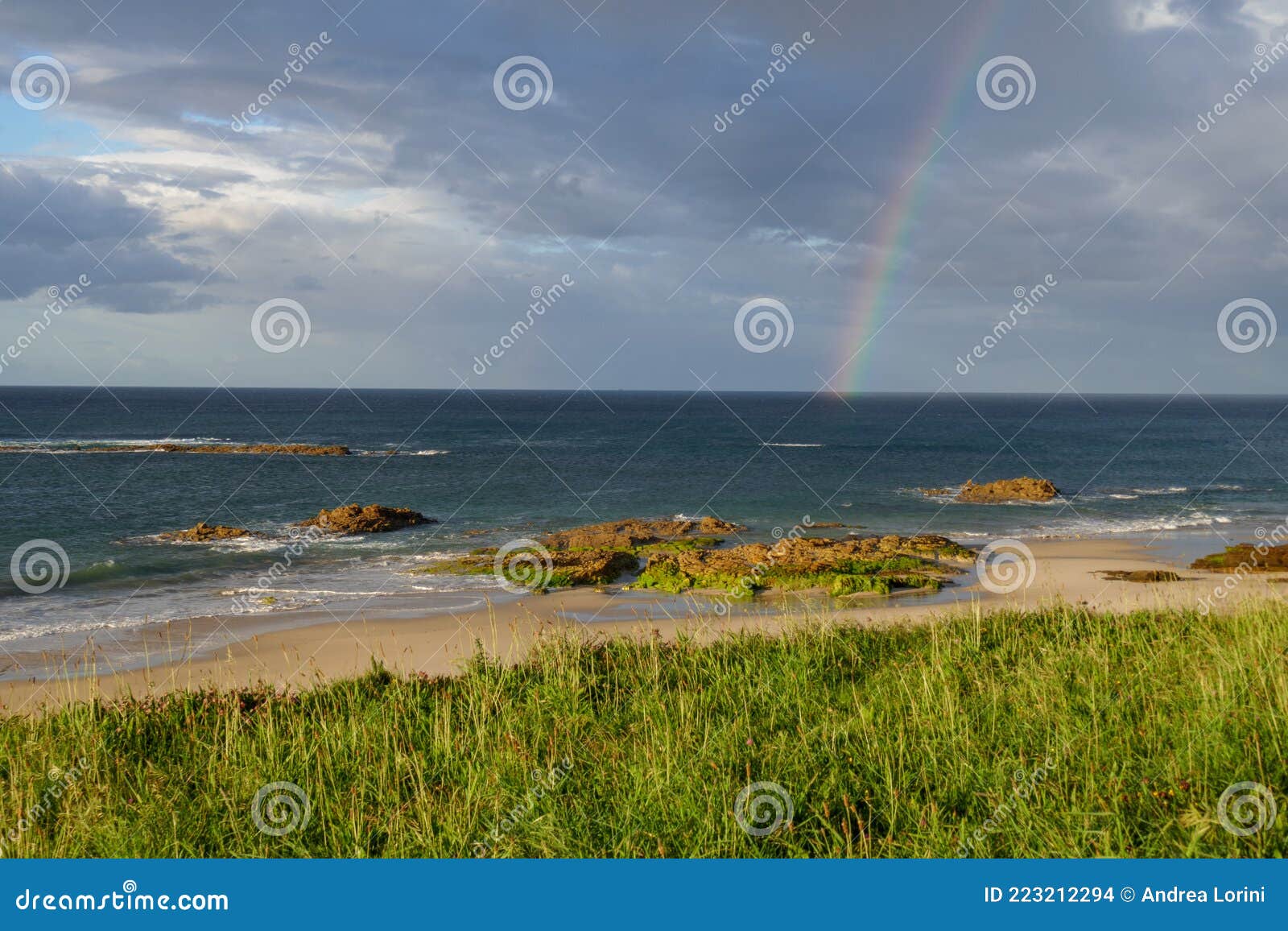 rainbow in sea from playa llas in foz, lugo, galicia. beautiful colorful landscape