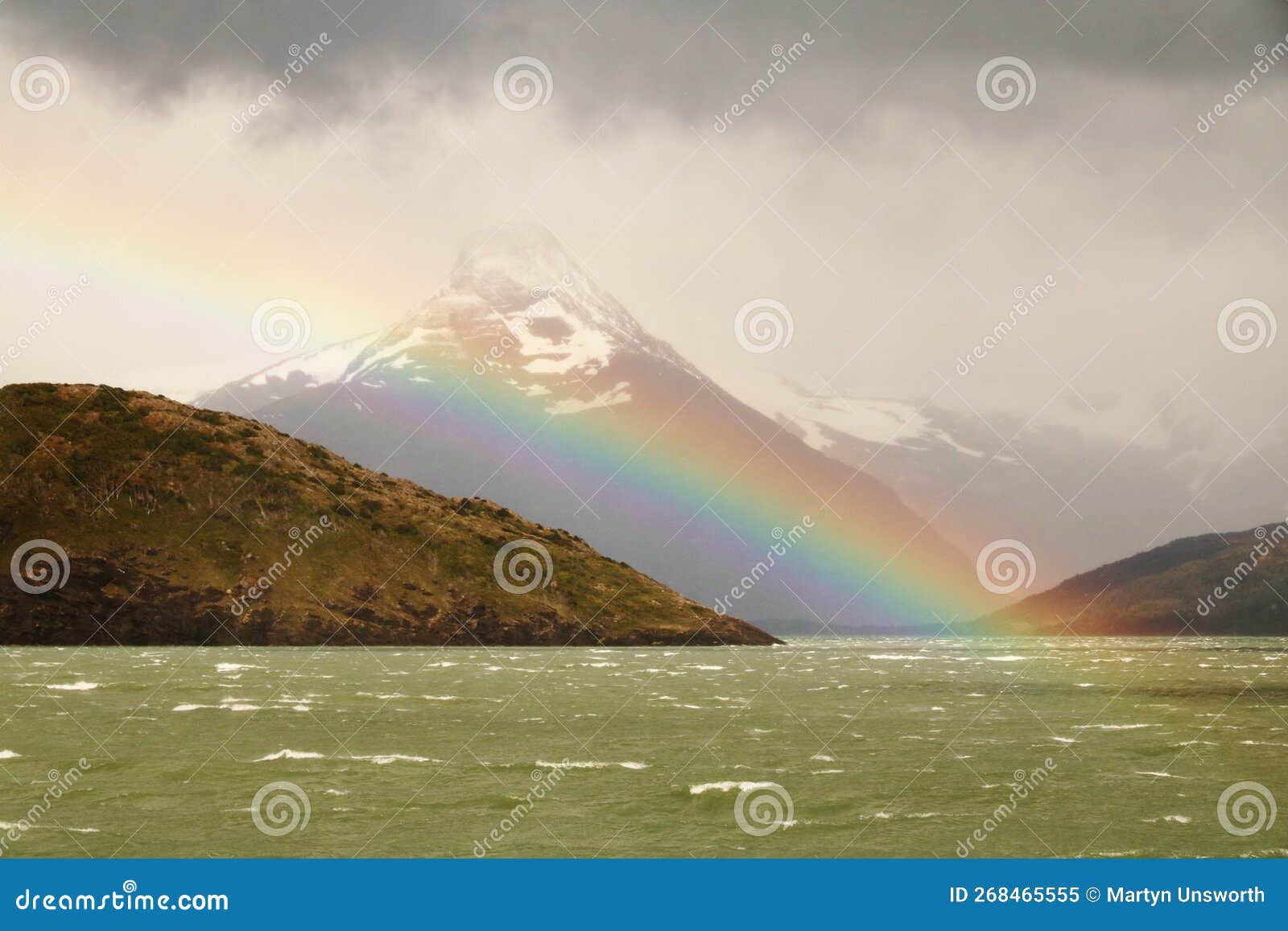 rugged mountains and a rainbow on seno de ultima esperanza, patagonia, chile