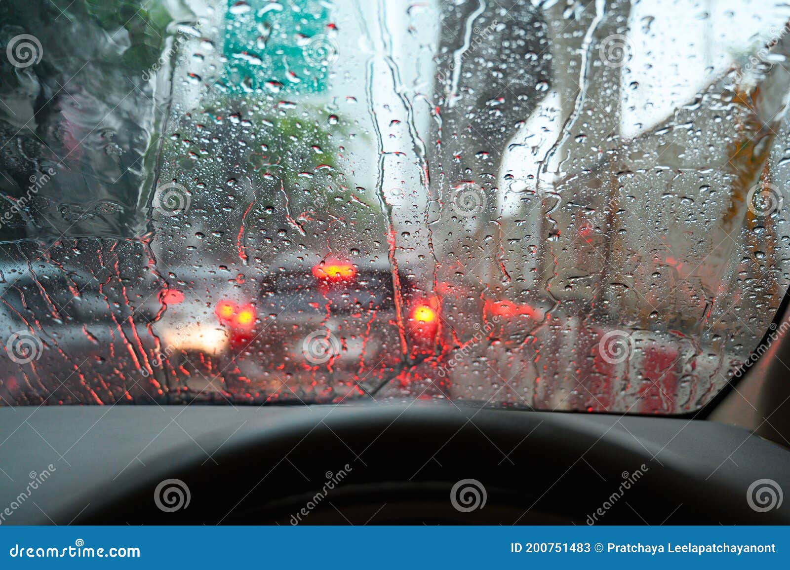 Raindrops Run Down on Car Windshield from Inside View. Traffic Jam