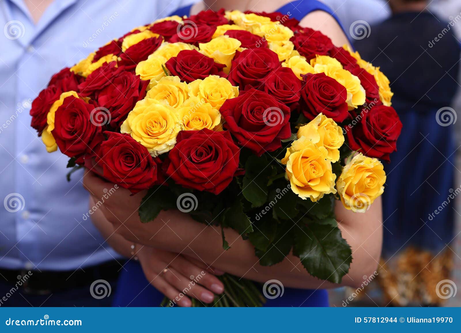 Ramo De Las Rosas Rojas Y Amarillas En Las Manos Foto de archivo - Imagen  de flora, flor: 57812944