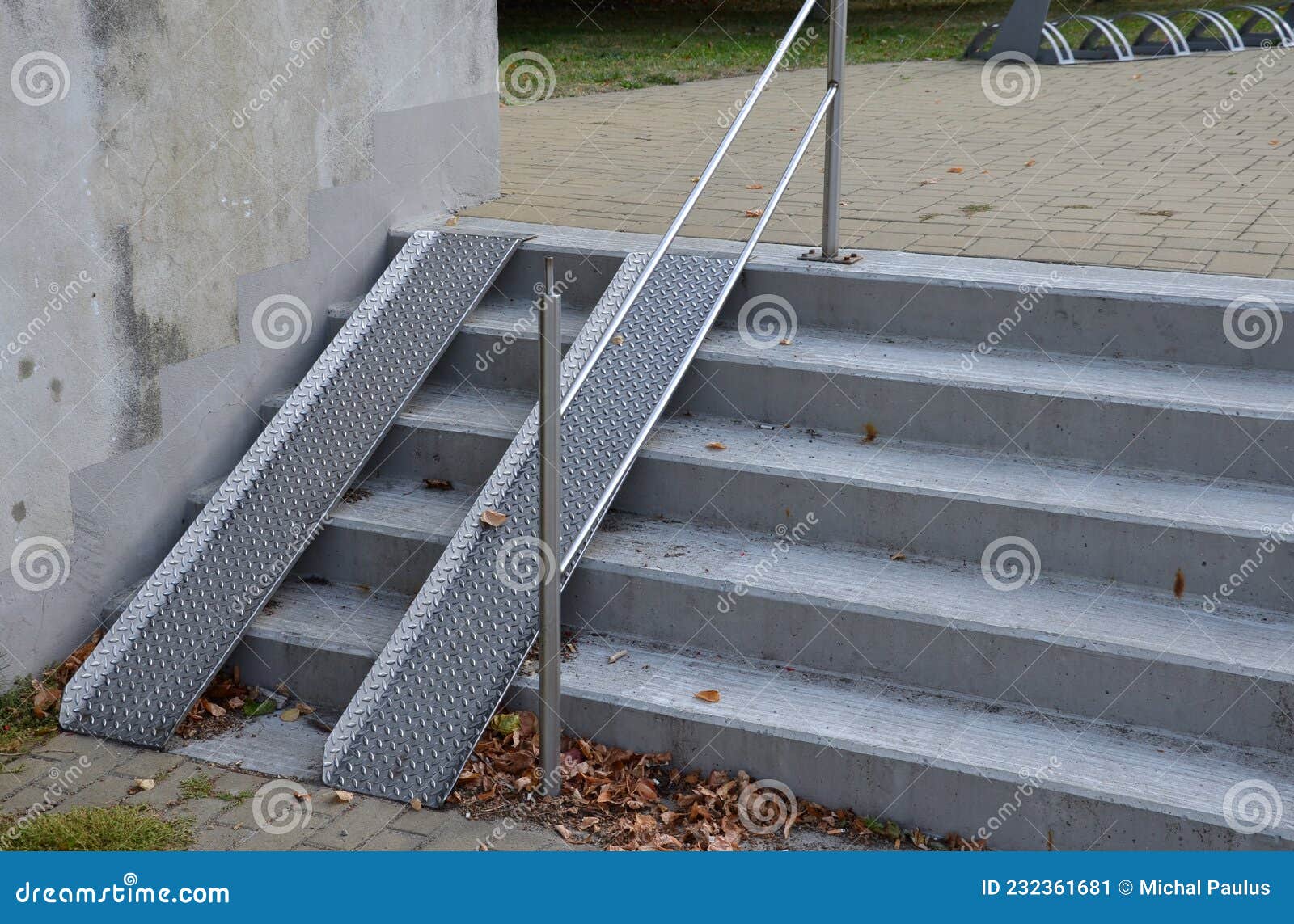 ramp combined with a gray concrete staircase and a handrail specially adapted for wheelchairs. security tasteful solution for ente
