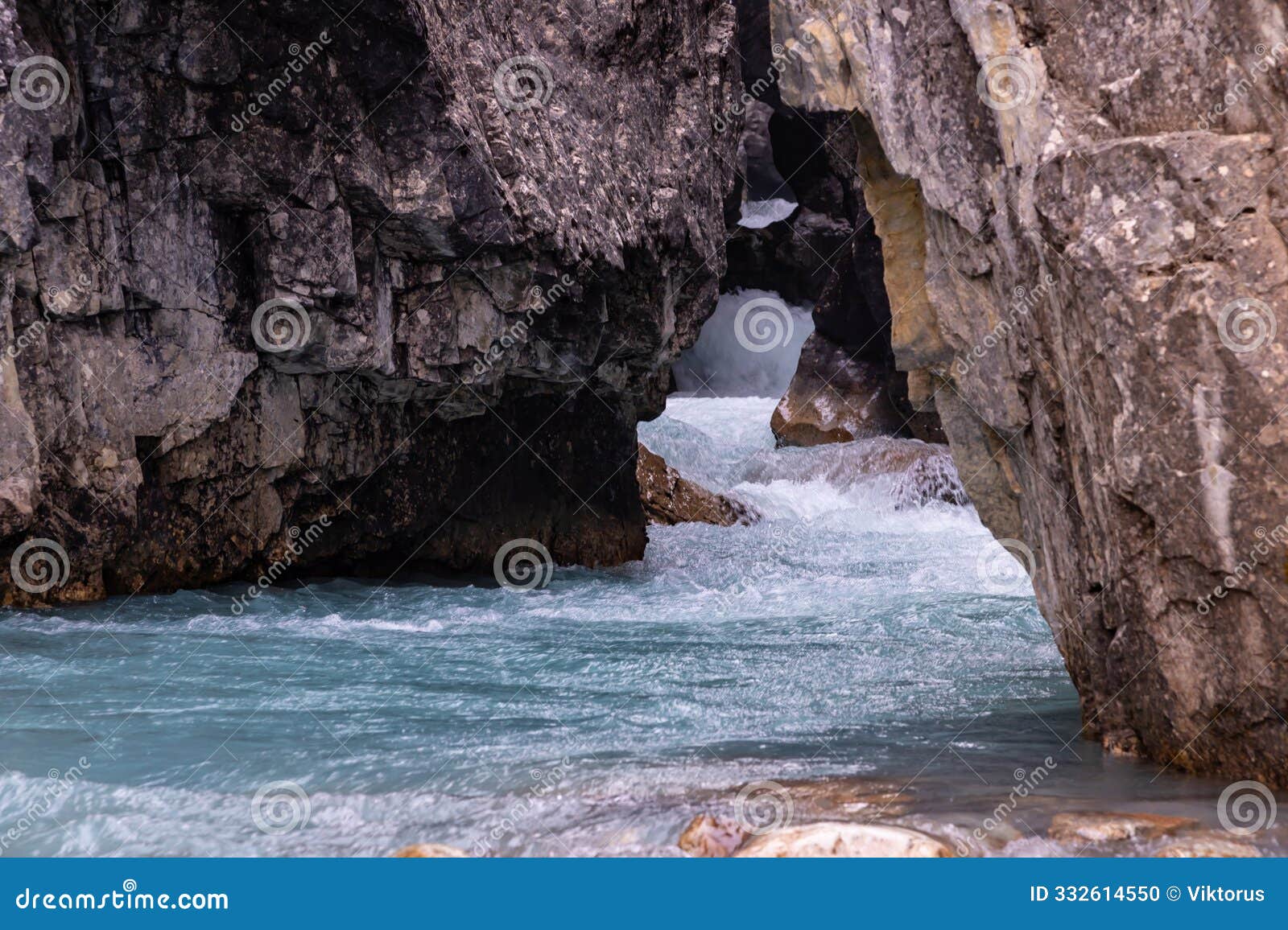 rapid crystal clear streams of mountain glacier bow river flow through the crack in the rock, banff, alberta, canada