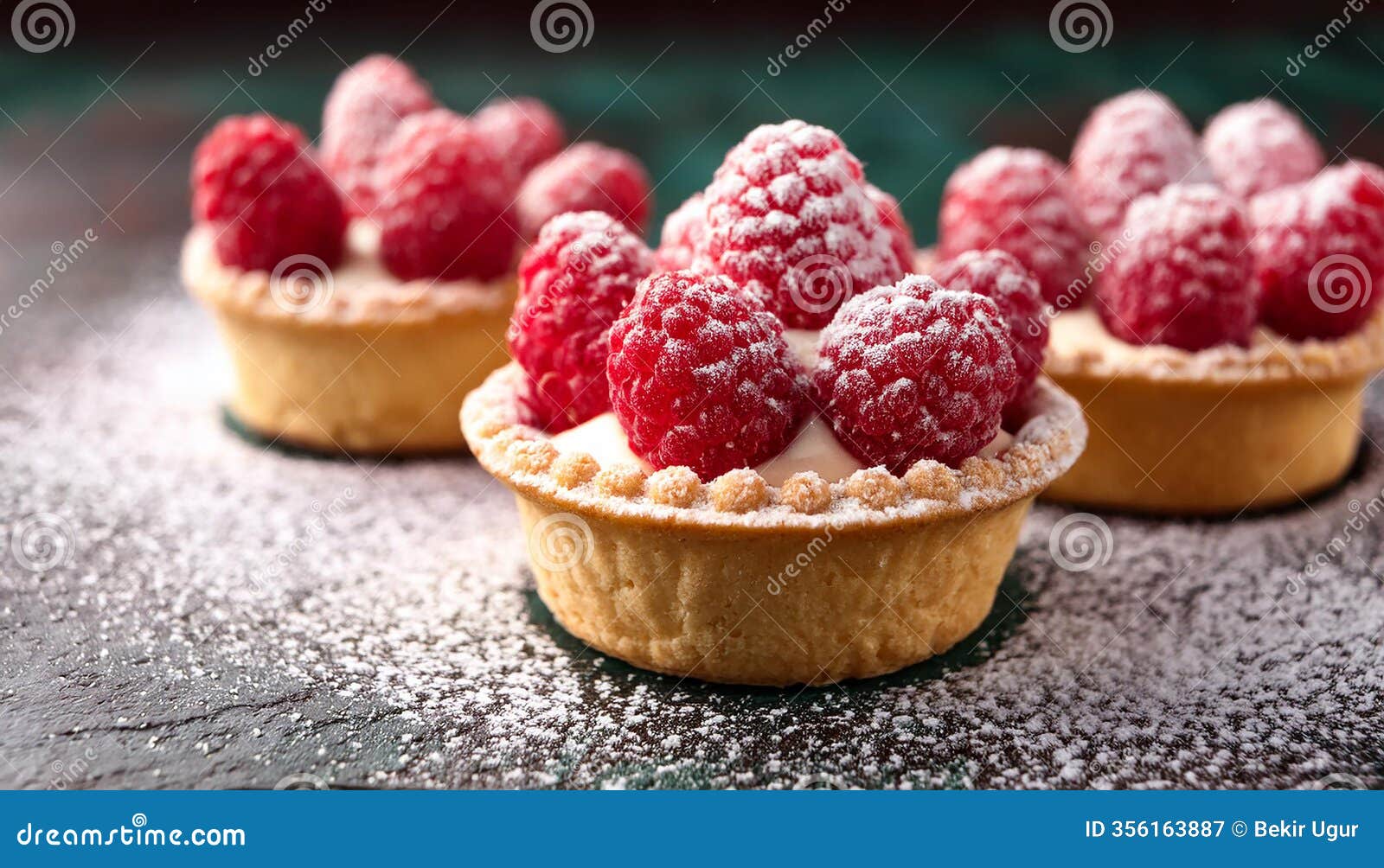 raspberry tartlets with cream filling and dusted with icing sugar.