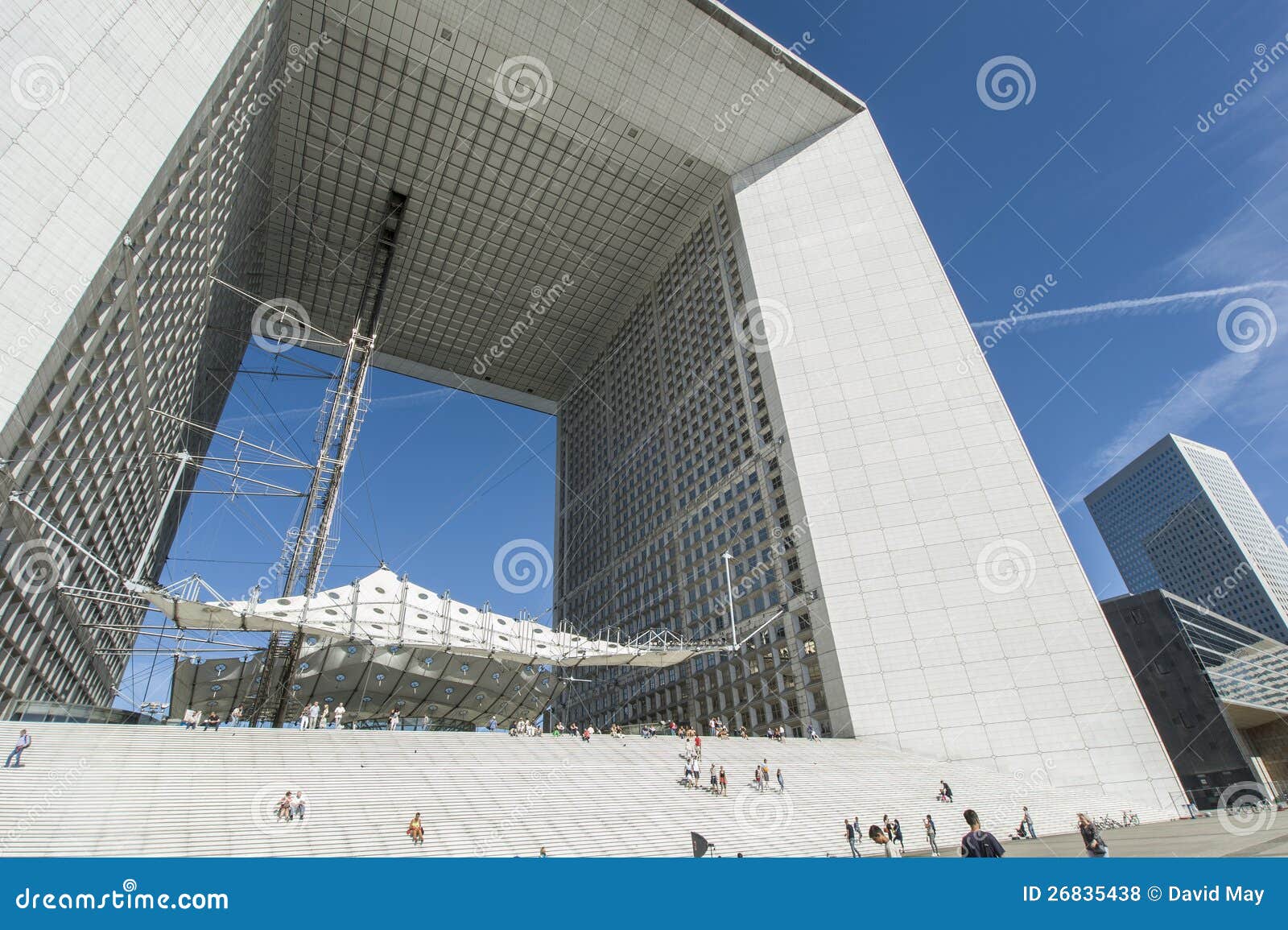 Rastros del vapor del La Grande Arche. La mirada a través del Grande Arche con el vapor arrastra el corte a través del cielo detrás de la defensa París del La Grande Arche en un día claro encantador del cielo azul.