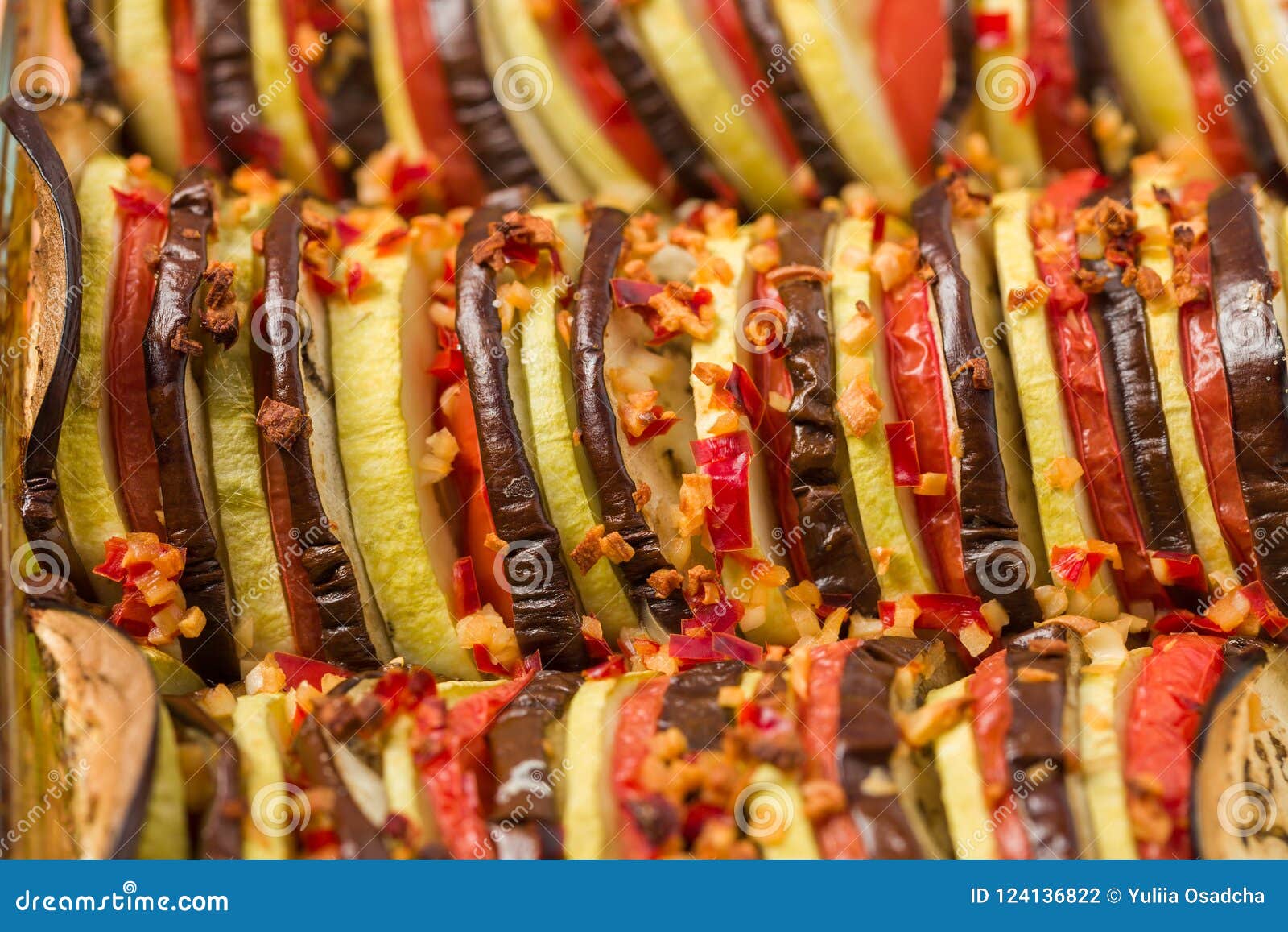 ratatouille close up macro photography with fresh cooked vegetarian meal on brown wooden background.