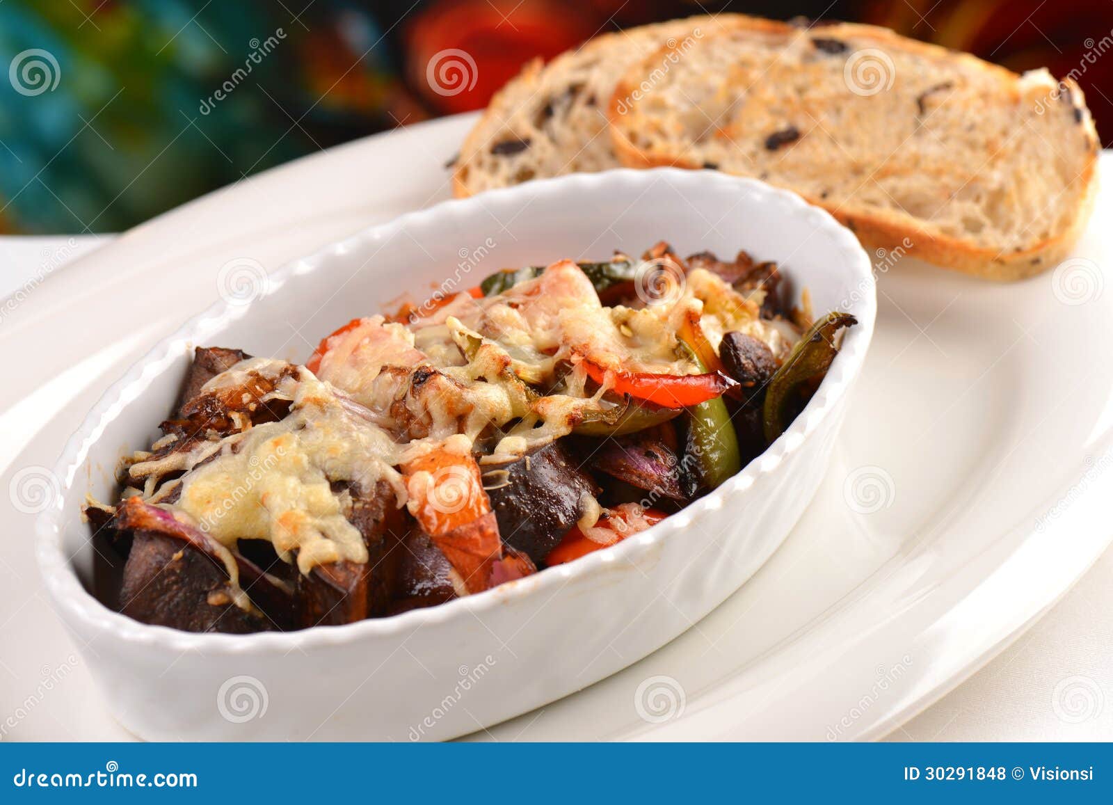 Ratatouille cozeu no forno com um queijo e um pão das azeitonas