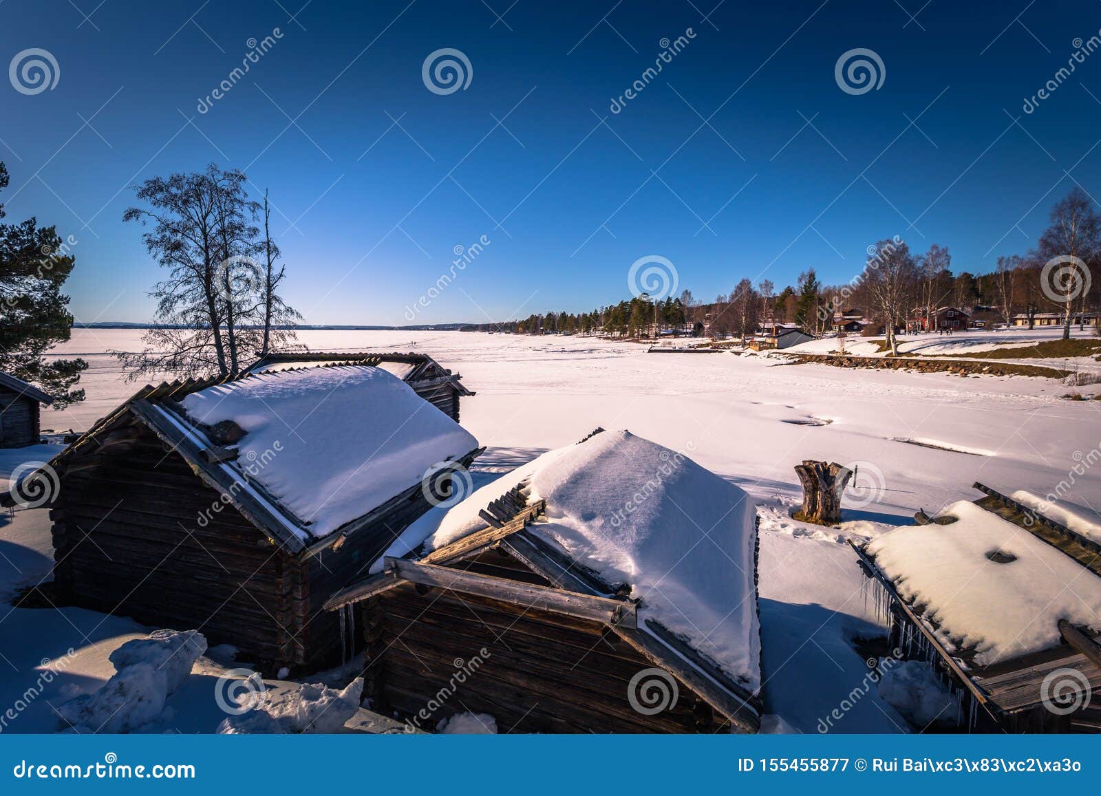 rattvik - march 30, 2018: wooden houses by the frozen lake siljan in rattvik, dalarna, sweden