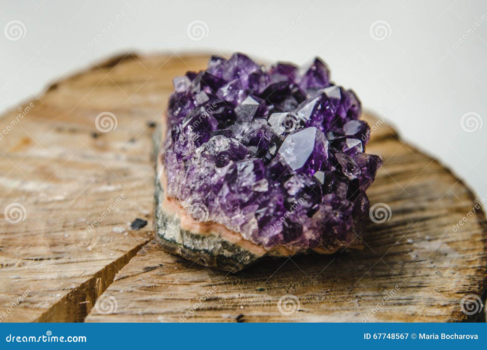 raw amethyst rock with reflection on natural wood crystal ametist