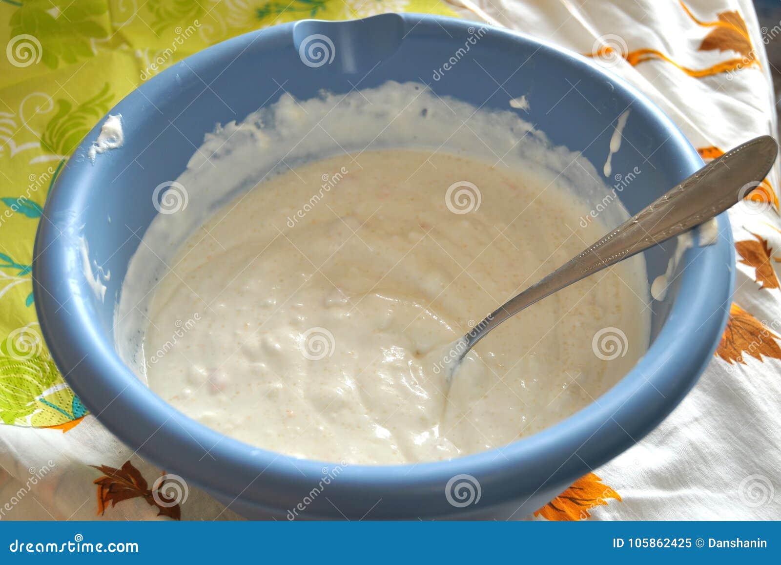 Raw Batter and a Spoon in a Deep Blue Plastic Bowl Closeup. Stock