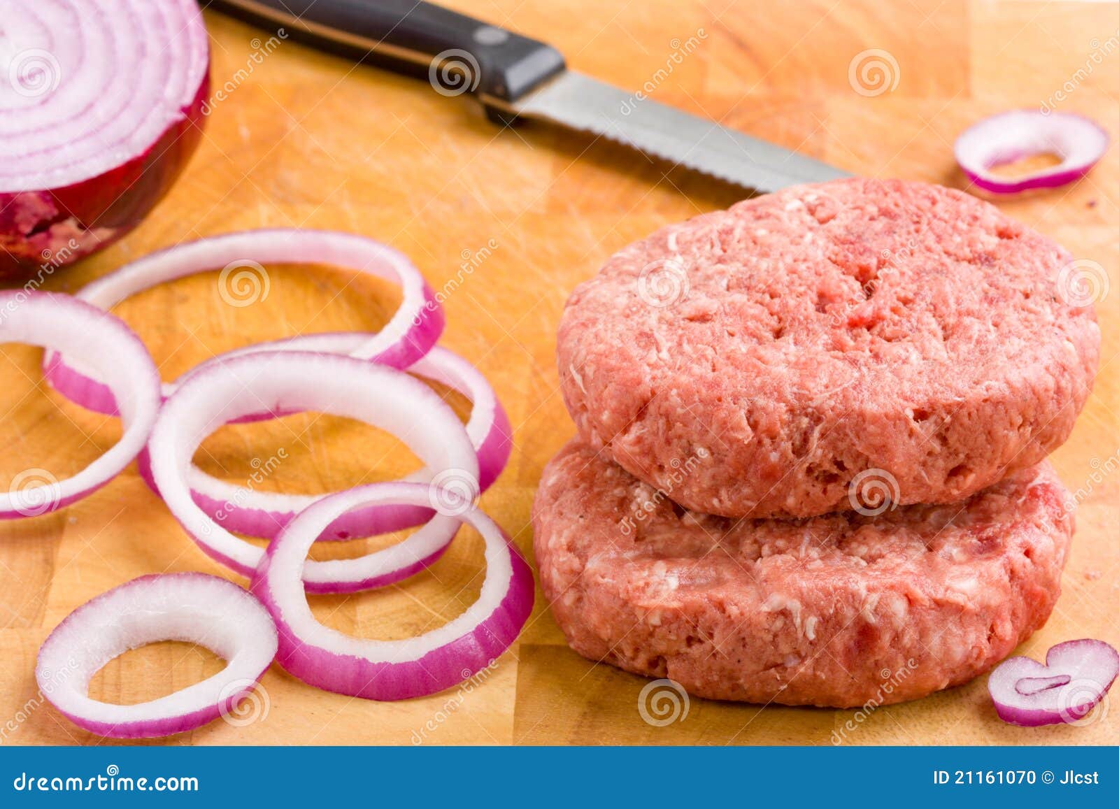 Raw Beef Burgers and Red Onion on Chopping Board. Stock Photo Image