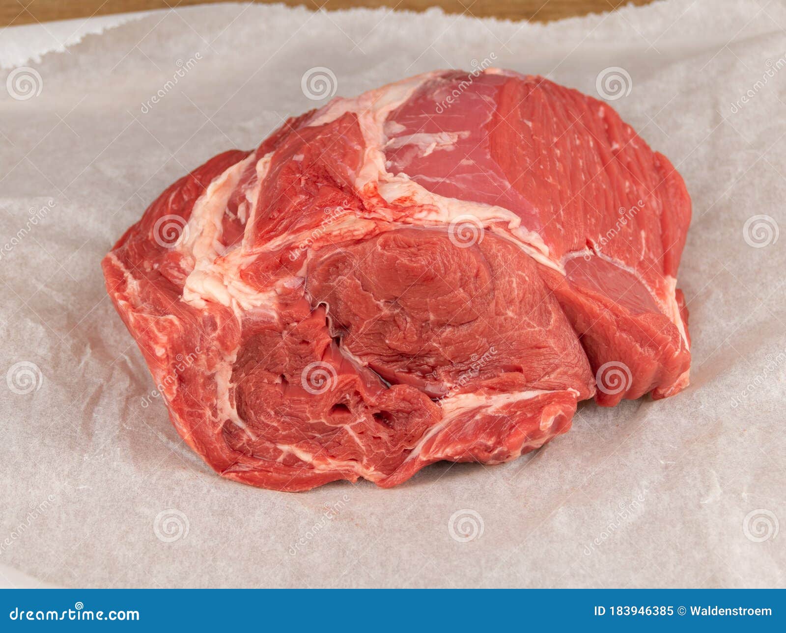 raw beef clod on white wrapping paper closeup