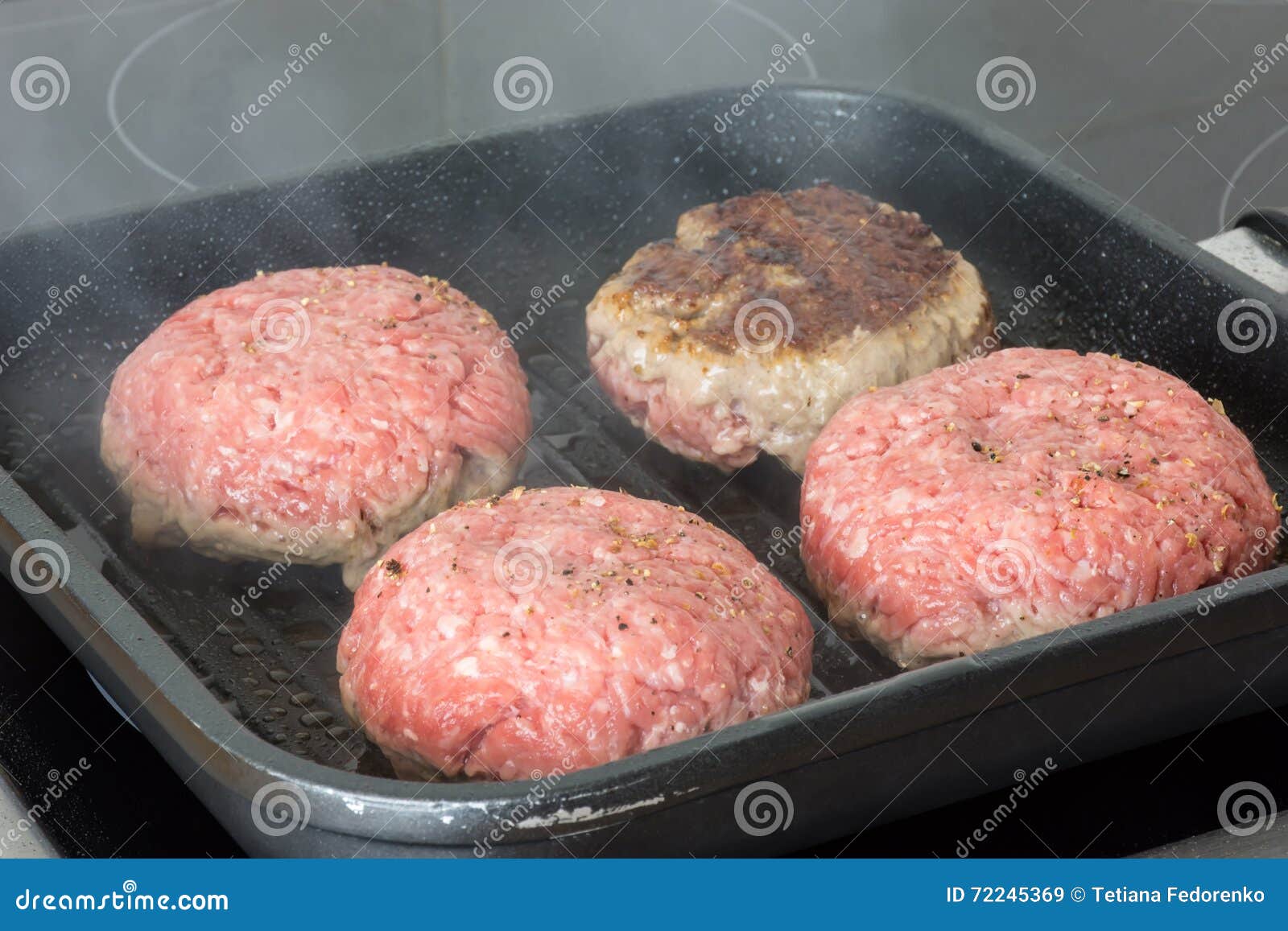 Raw Burgers, Beef in a Frying Pan on Cooking Surface in Kitchen Stock